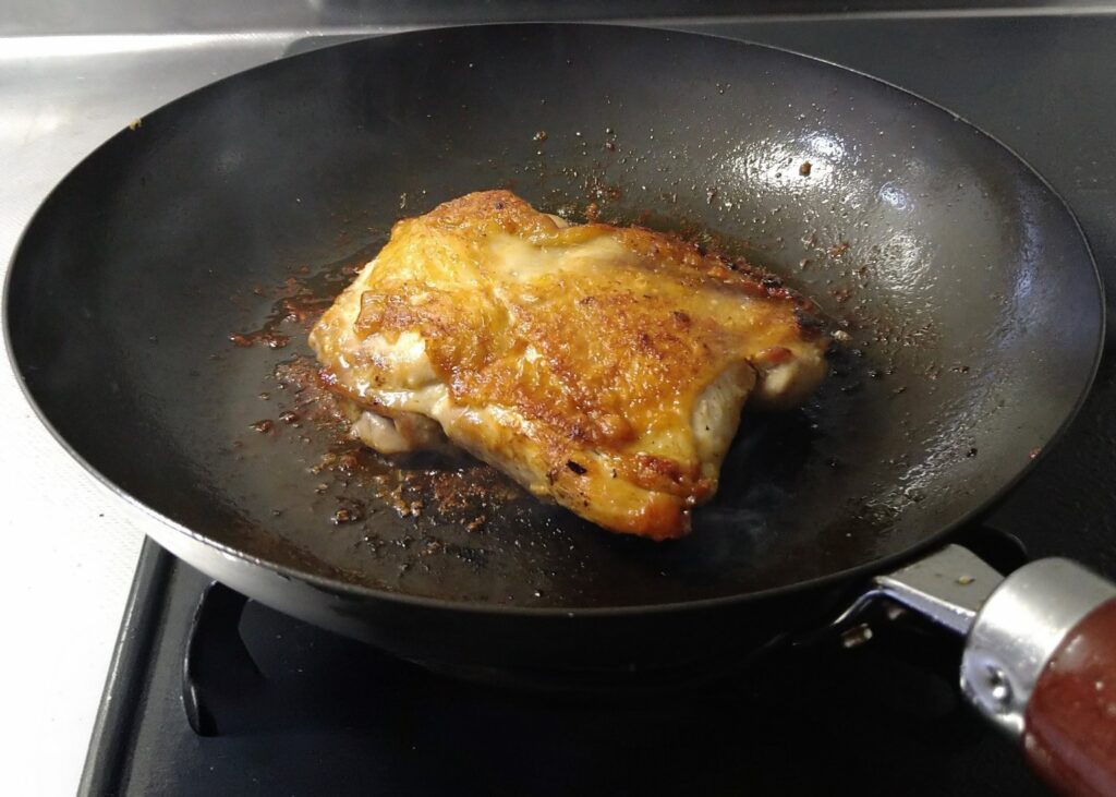 crispy chicken thigh in cast iron pan